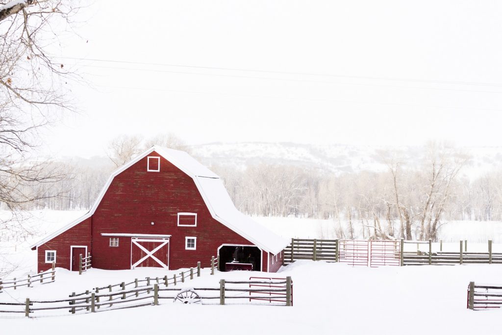A red barn surrounded by snow